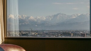 A view from a window overlooking a cityscape with mountains in the background. - Oarks canal park hotel Toyama (Toyama)