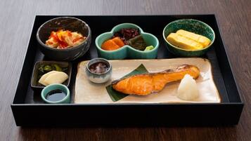 A traditional Japanese meal with salmon, rice, and various side dishes in a black tray.