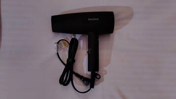 Un sèche-cheveux noir avec un câble et un adaptateur secteur.