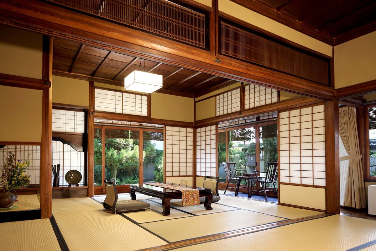 Une pièce de style japonais traditionnel, avec un sol recouvert de tatamis, une basse table en bois et des portes coulissantes.
