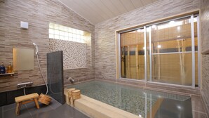 Casa de banho moderna com banheira de hidromassagem envidraçada, bancos de madeira, uma janela grande e zona de duche.