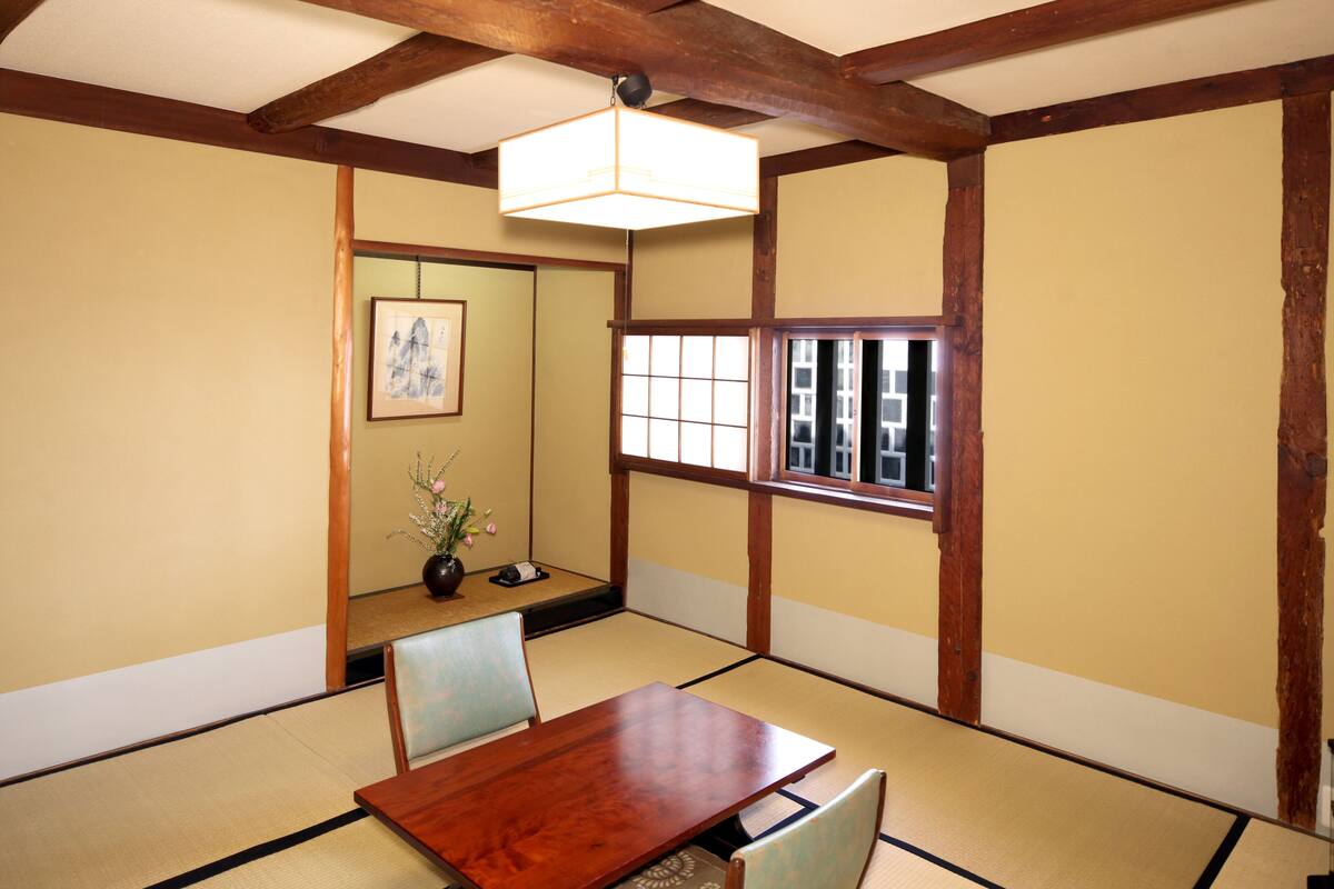 Une pièce de style japonais traditionnel, avec un sol recouvert de tatamis, une table en bois et un paravent shoji.