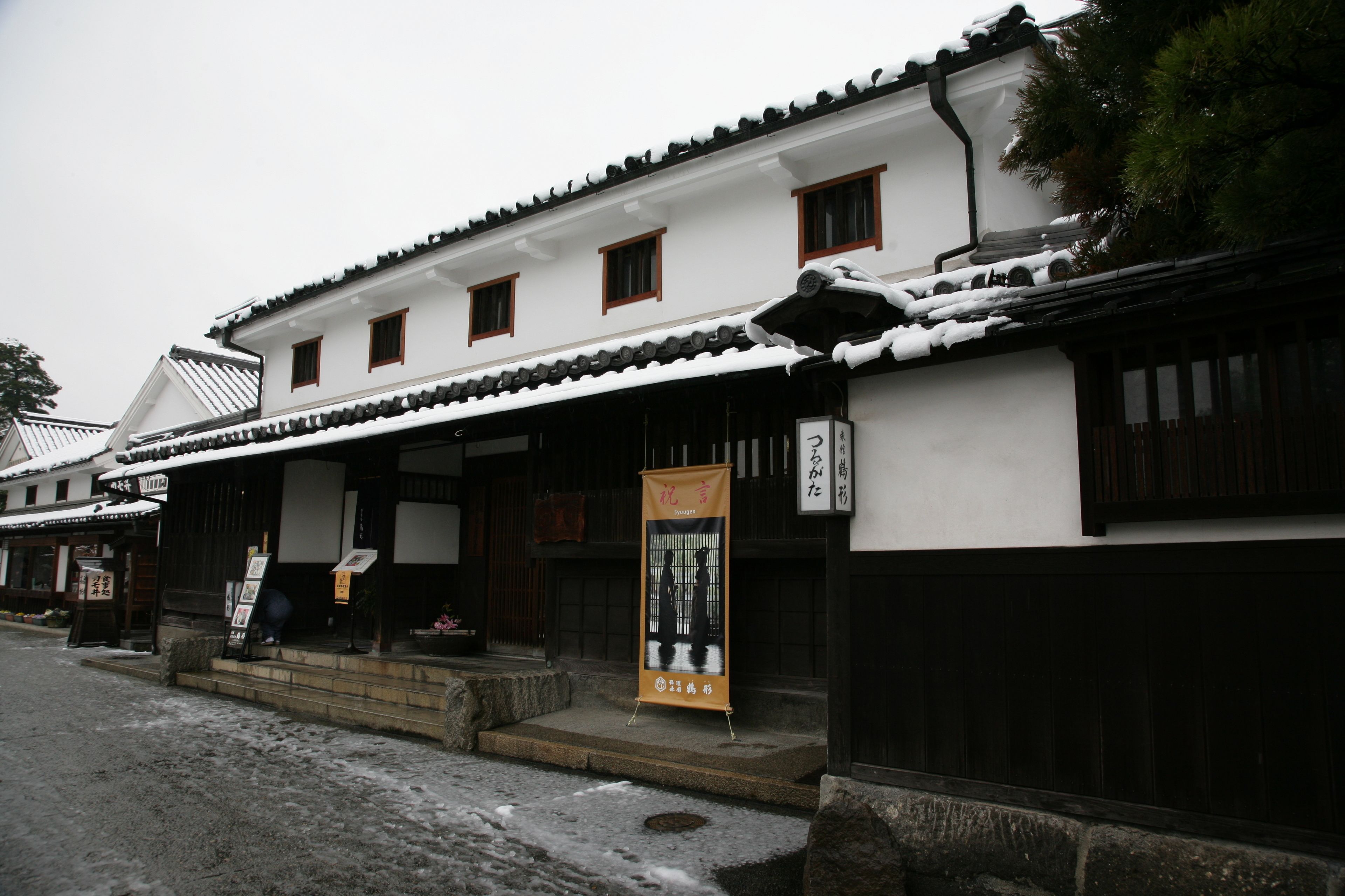 Um edifício tradicional japonês com telhado ladrilhado e fachada de madeira.
