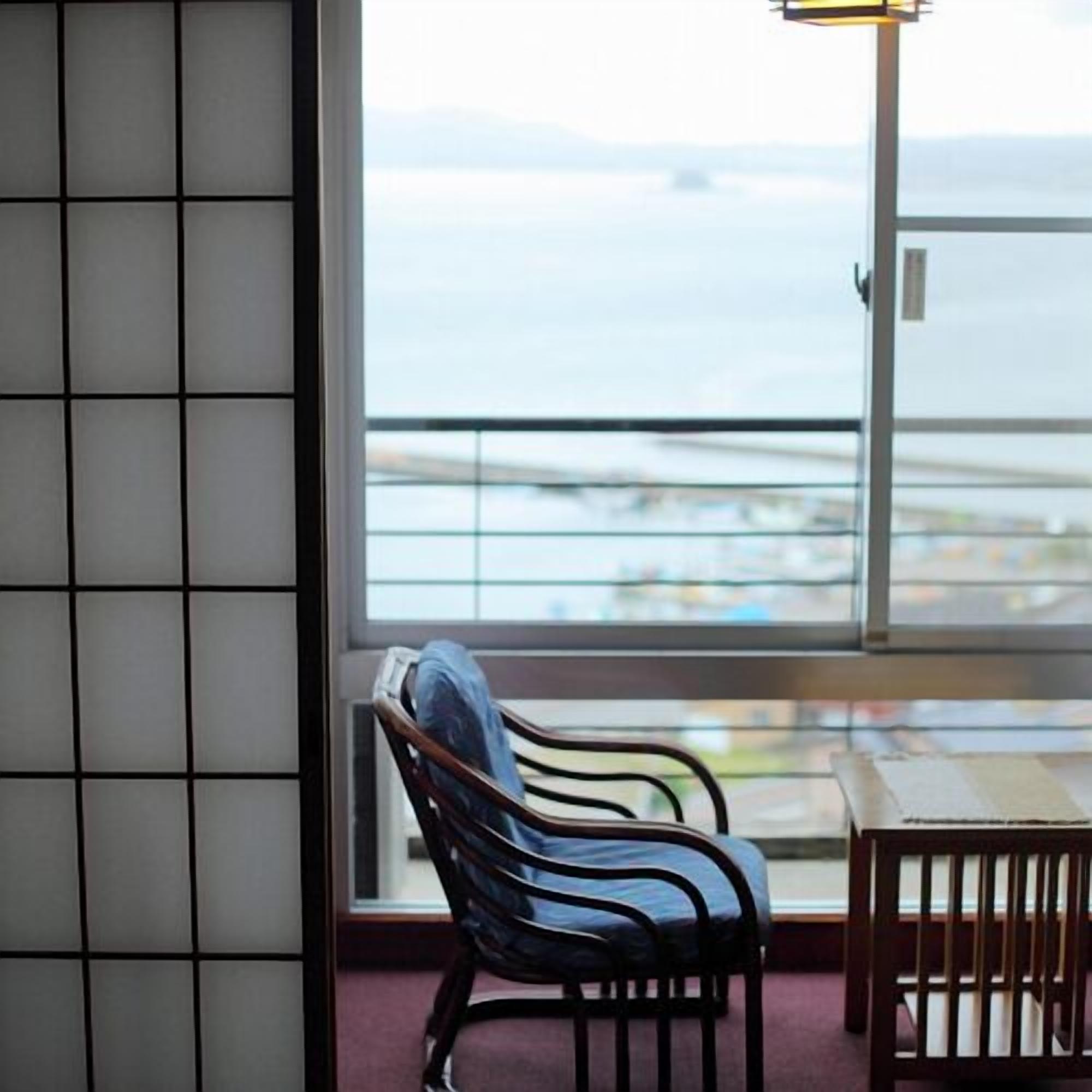 Une pièce avec vue sur la mer, une chaise et une table.