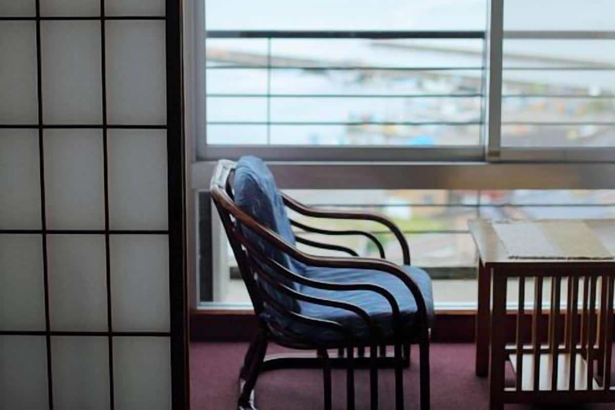Une pièce avec vue sur la mer, une chaise et une table.