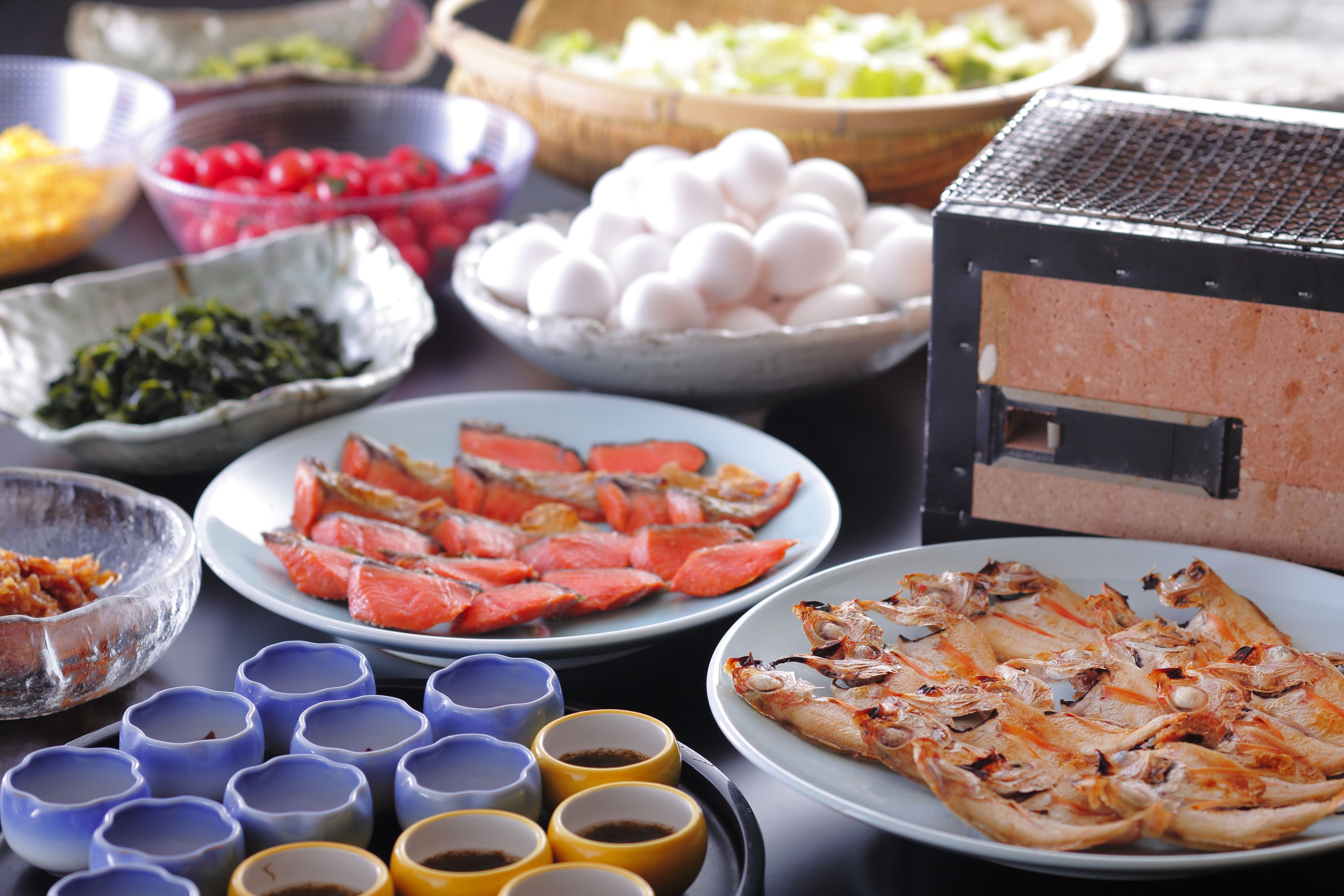 A variety of dishes including seafood, eggs, and sauces on a table.