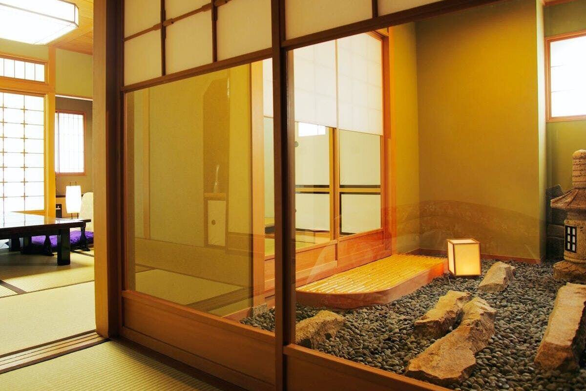 A traditional Japanese room with tatami flooring, a low wooden table, and a small rock garden.