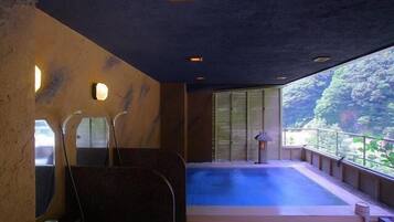 A hot tub area with a view of a forested landscape.