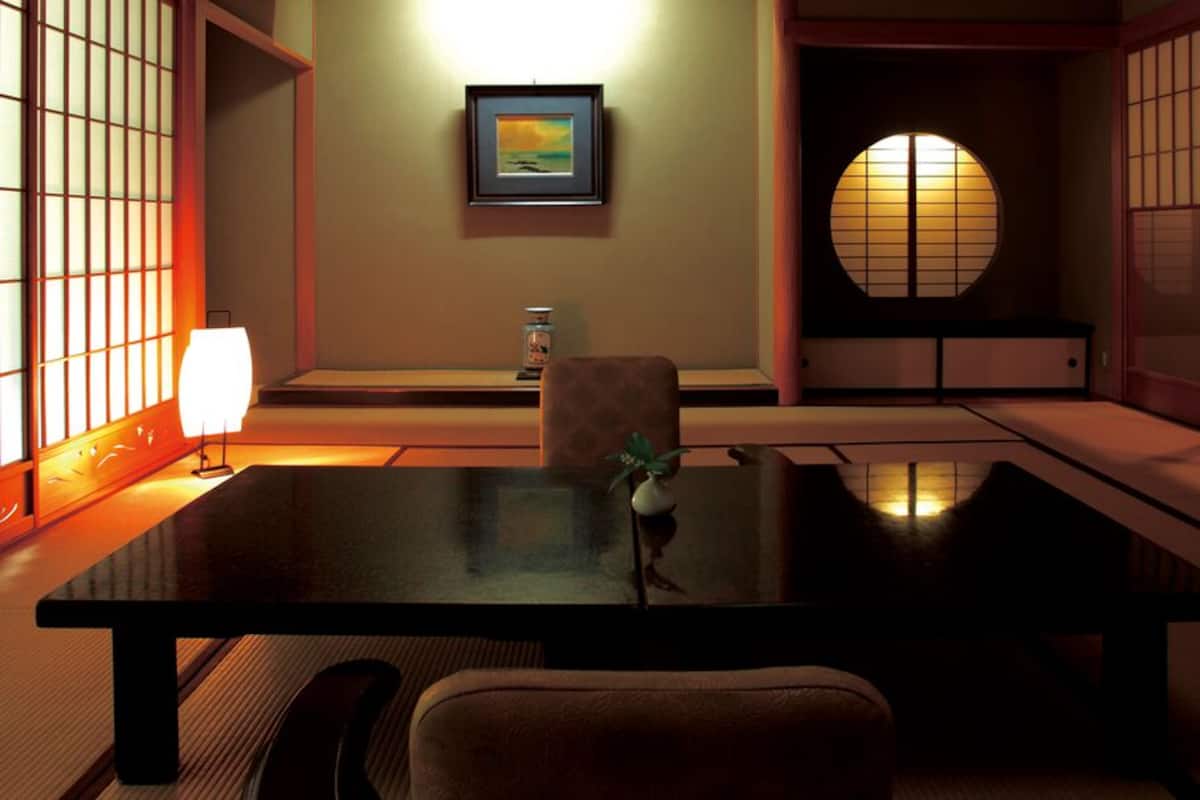 A traditional Japanese room with tatami flooring, a low table, and shoji screens.