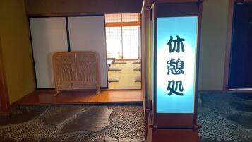 Una habitación japonesa tradicional con suelo de tatami, pantalla shoji y un futón.