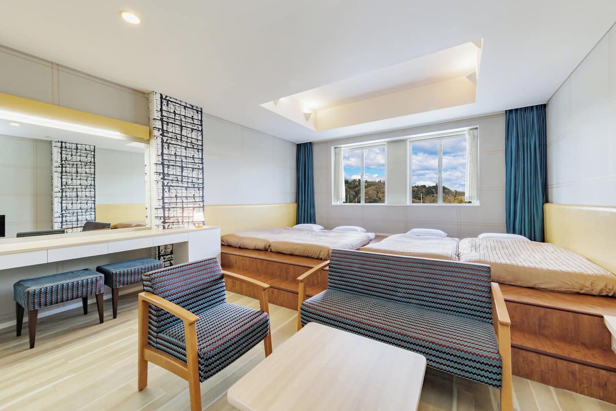 A modern hotel room with a large bed, a desk, and a chair.