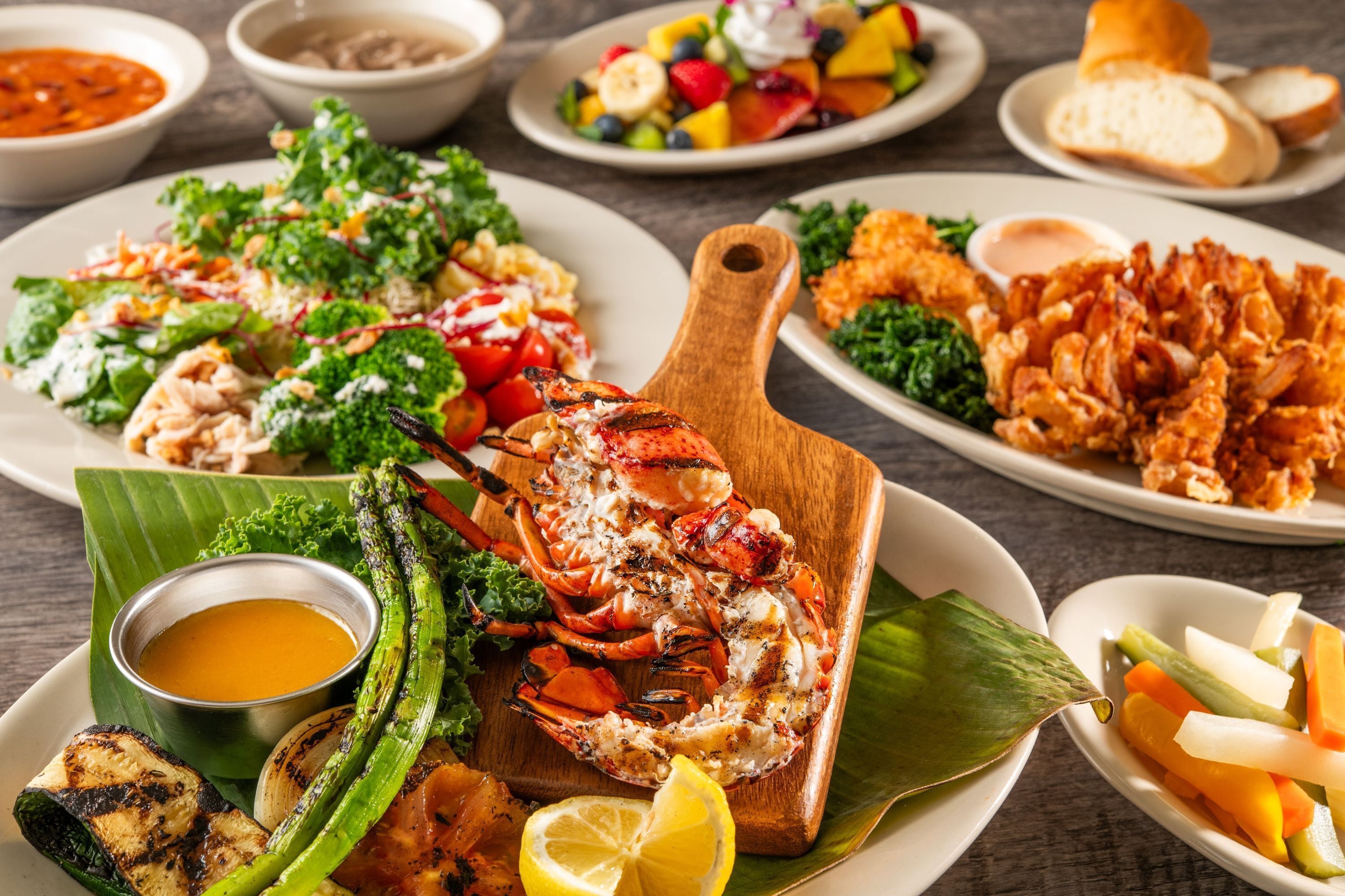 Variedad de platos de mariscos, incluyendo preparaciones a la parrilla y brochetas.