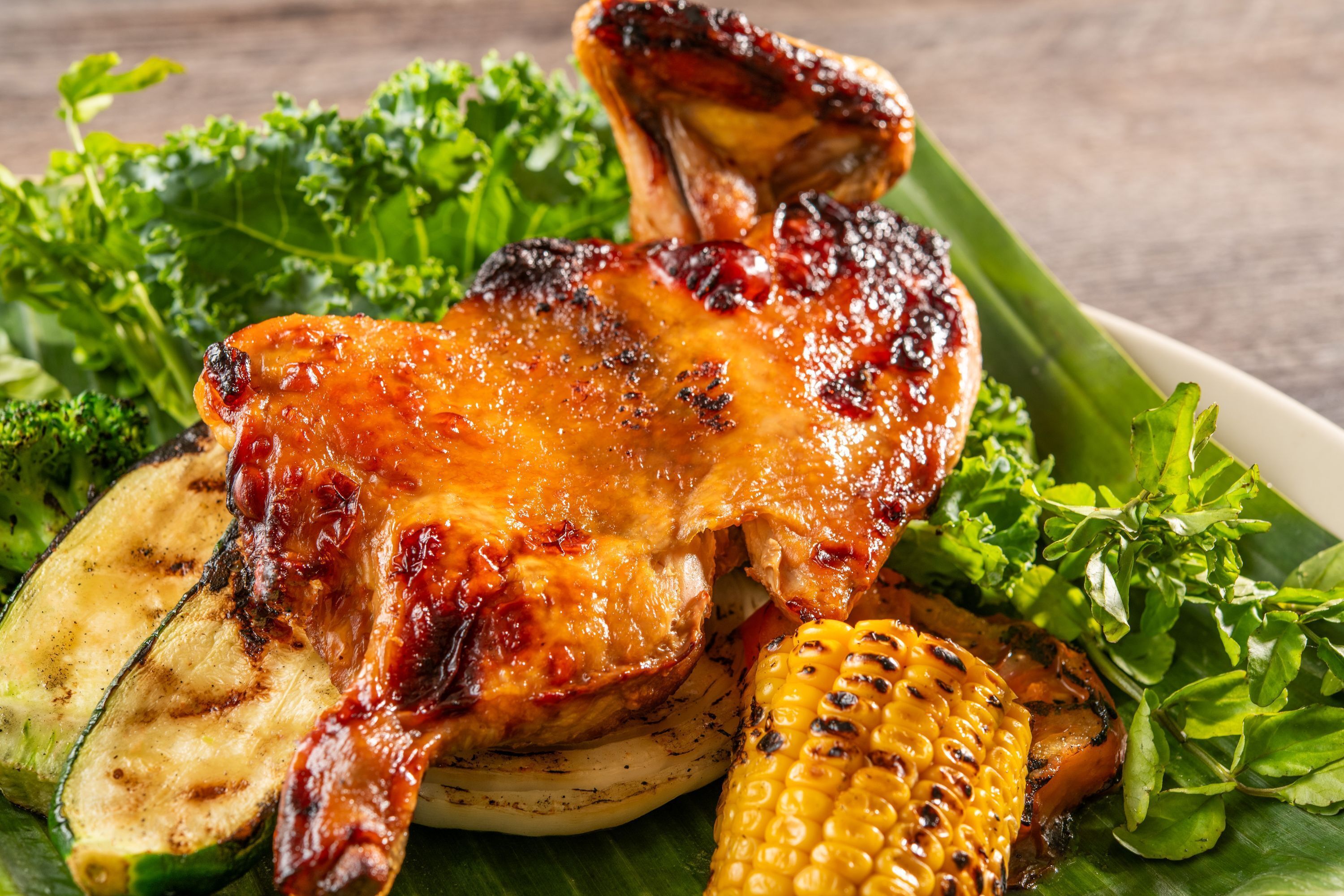 A grilled chicken with vegetables on a plate.