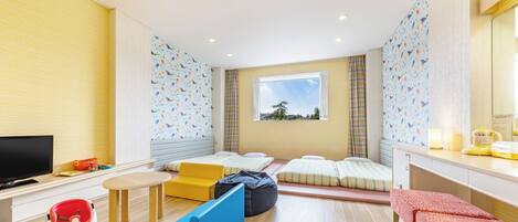 A modern room with a bed, a desk, a TV, and a window with a view.