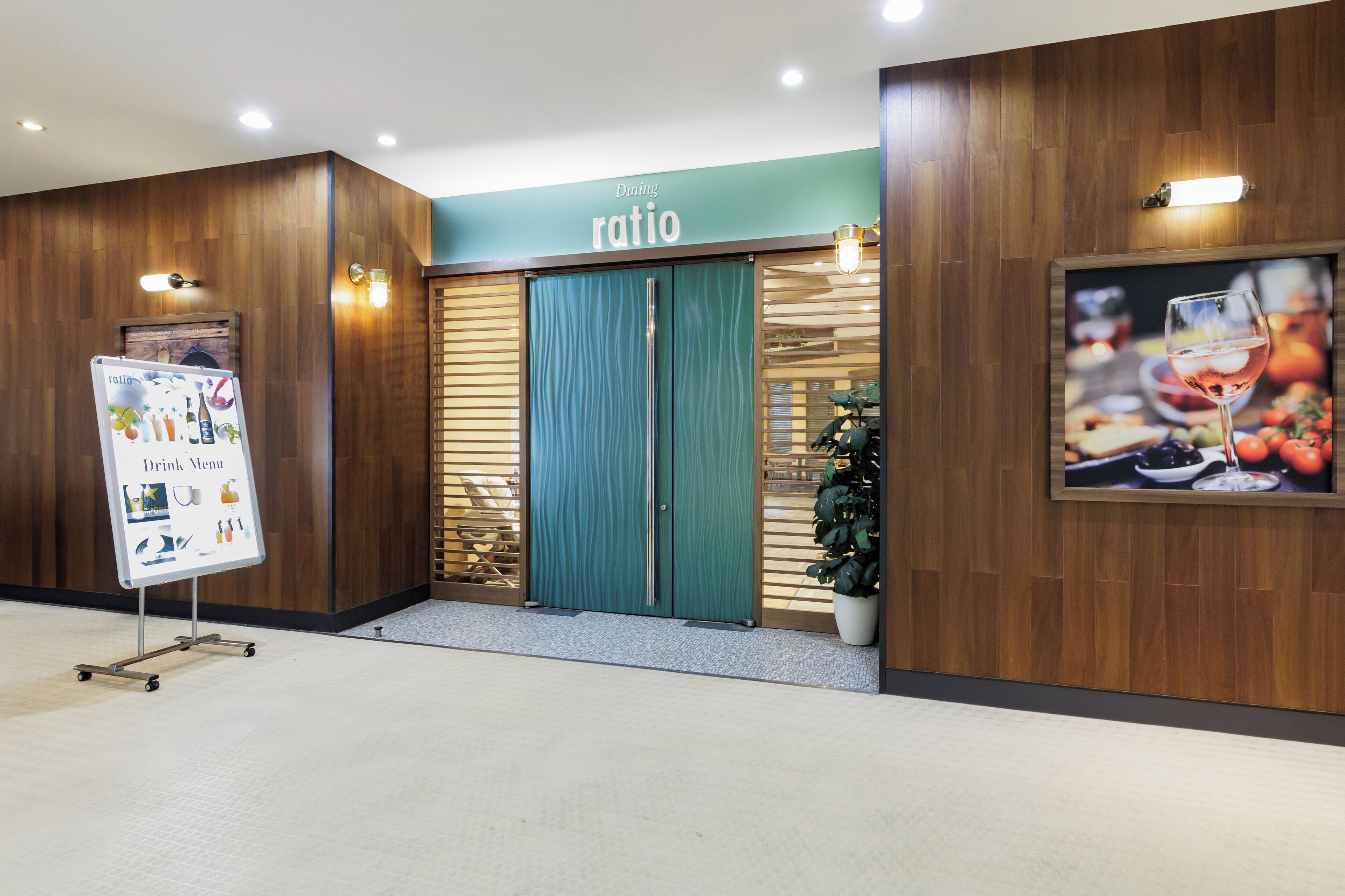 A restaurant entrance with wooden paneling, a green door, and a menu stand.