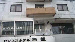A multi-story building with a sign for 'e-GA NA' and a sign for 'ビジネスホテル角島'. - Hotel Kakuban (Yonago)