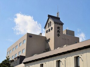 Un edificio con una torre destacada y señalización.