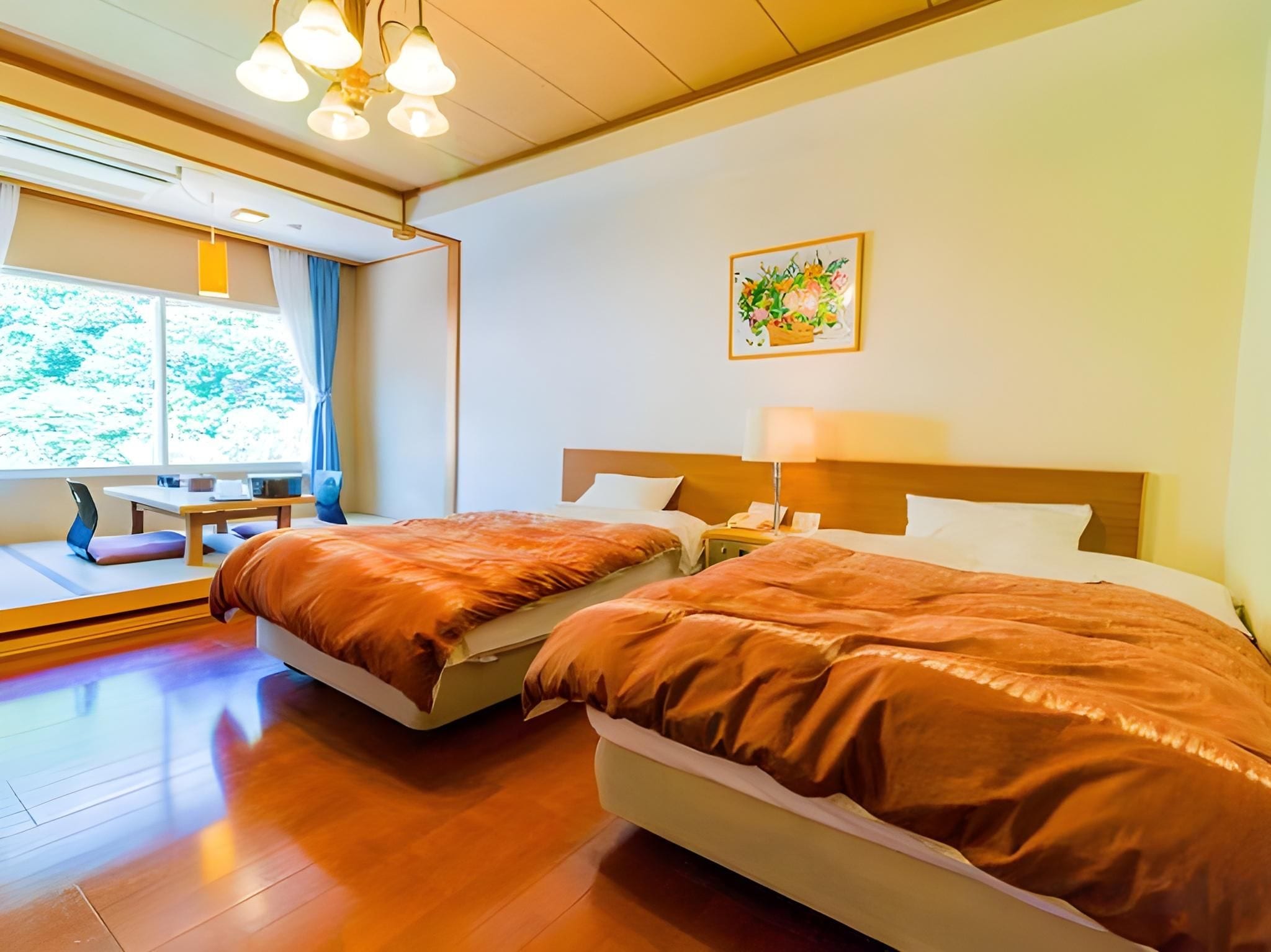 A hotel room with two beds, a desk, and a window with curtains.