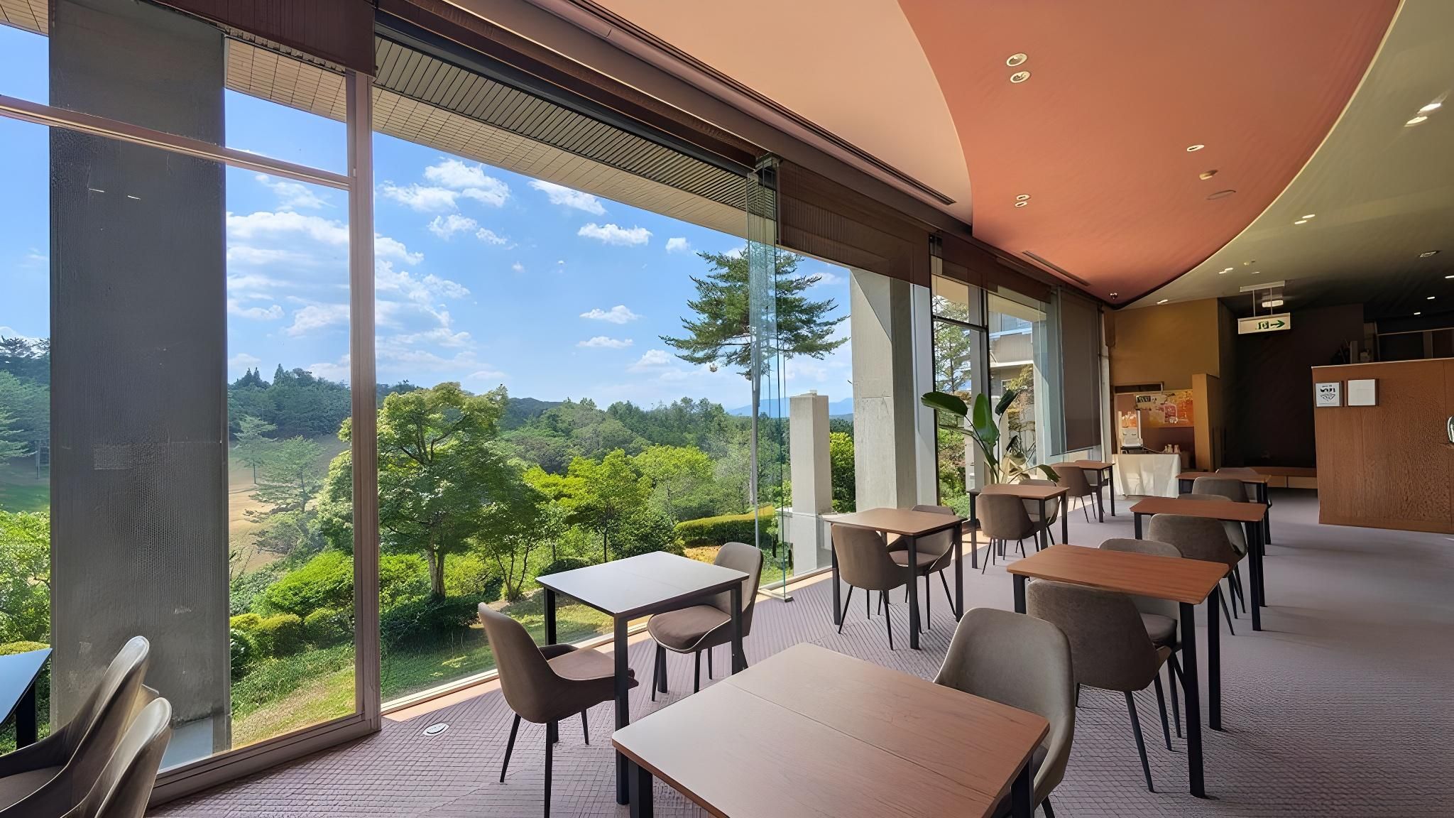 A modern interior with large windows offering a view of a forested landscape.