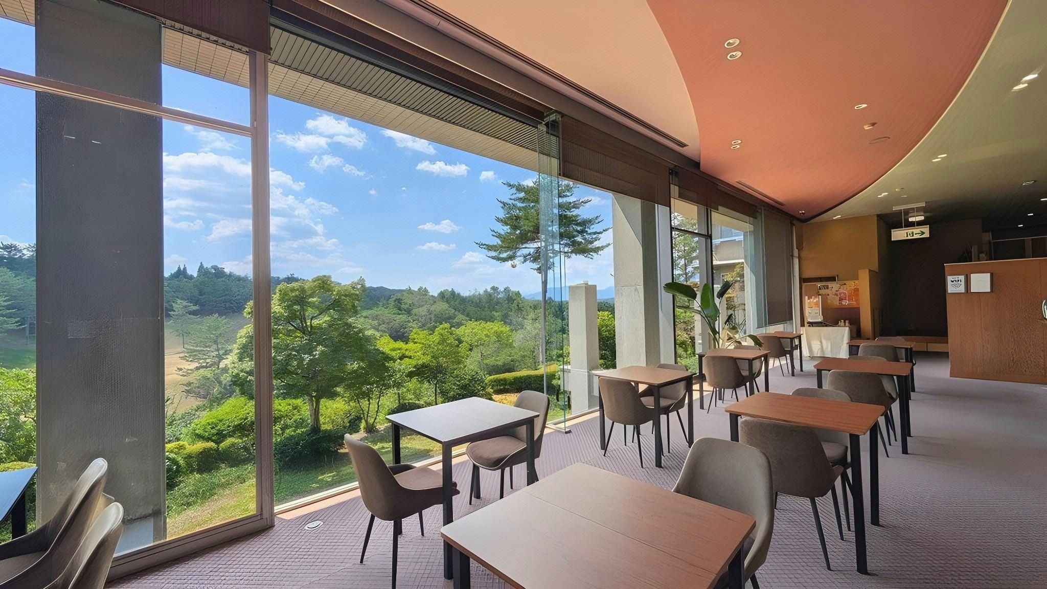 A modern interior with large windows offering a view of a forested landscape.
