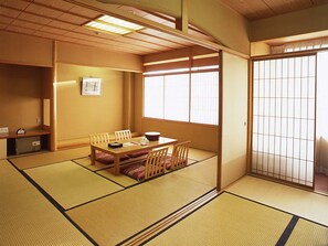 A traditional Japanese room with tatami flooring, a low wooden table, and sliding shoji doors. - Hotel Sakushu Musashi (Mimasaka)