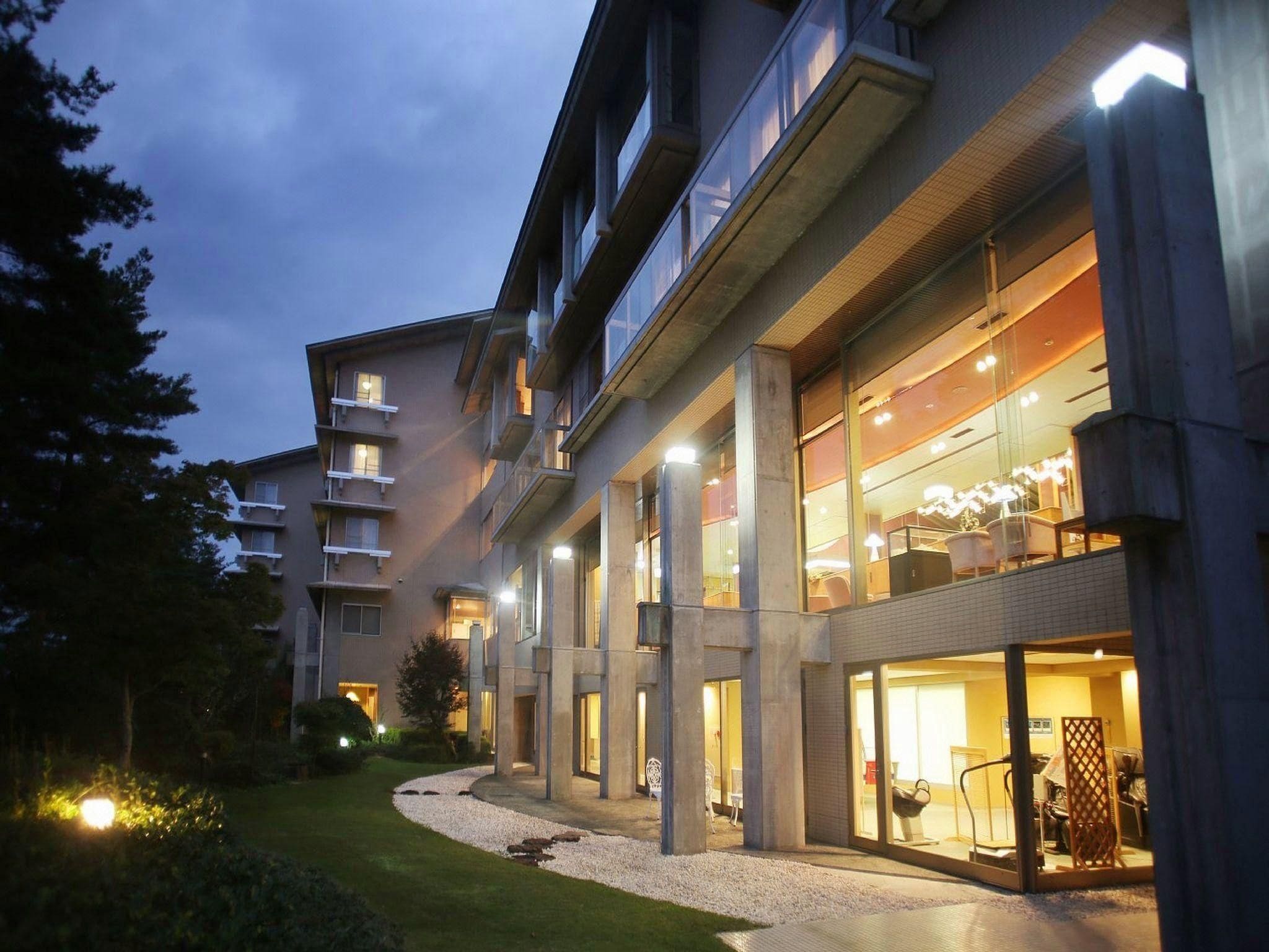 A multi-story hotel with a modern architectural design, featuring balconies and large windows.