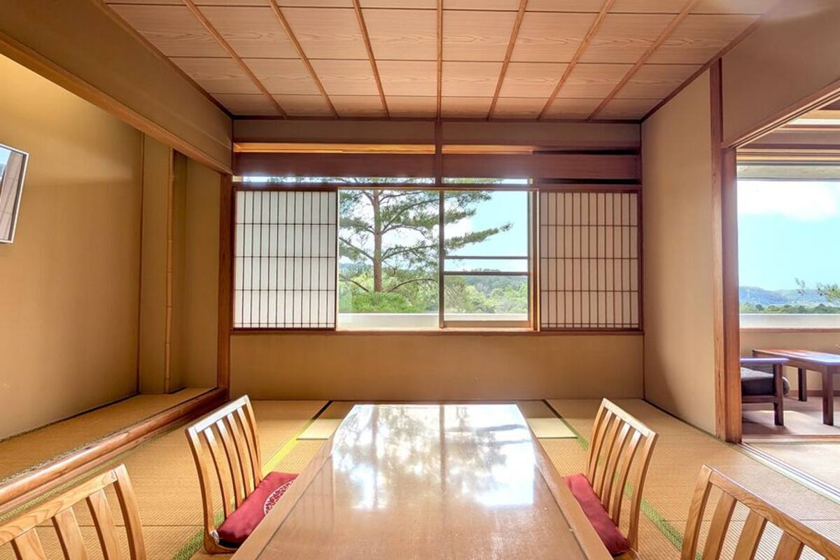A traditional Japanese room with tatami flooring, a low table, and shoji screens.