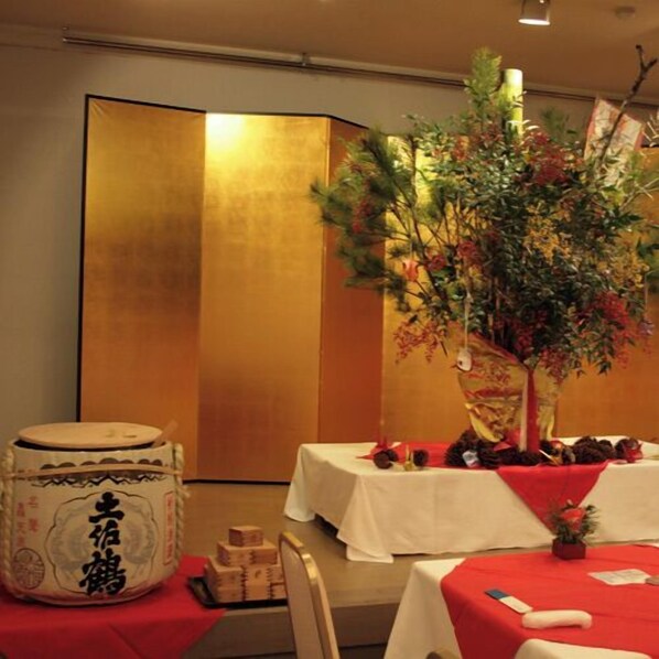 A room with a traditional Japanese aesthetic, featuring a tatami mat floor, a low table with a white tablecloth, and a decorative tree with red flowers. - Resort Hotel Umibe no Kajuen (Konan)