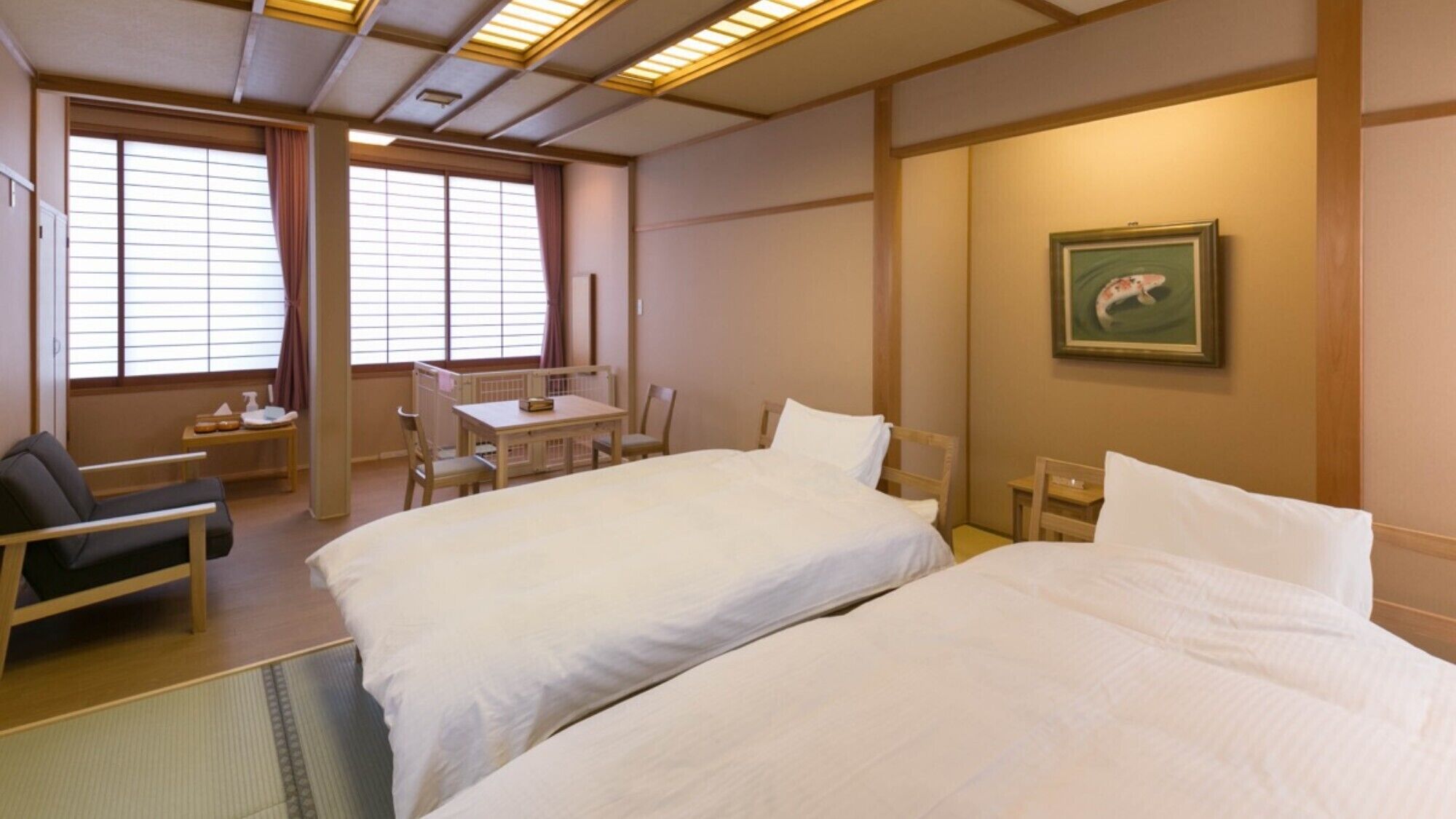 Habitación de hotel con dos camas, un escritorio, una silla y una ventana con persianas.