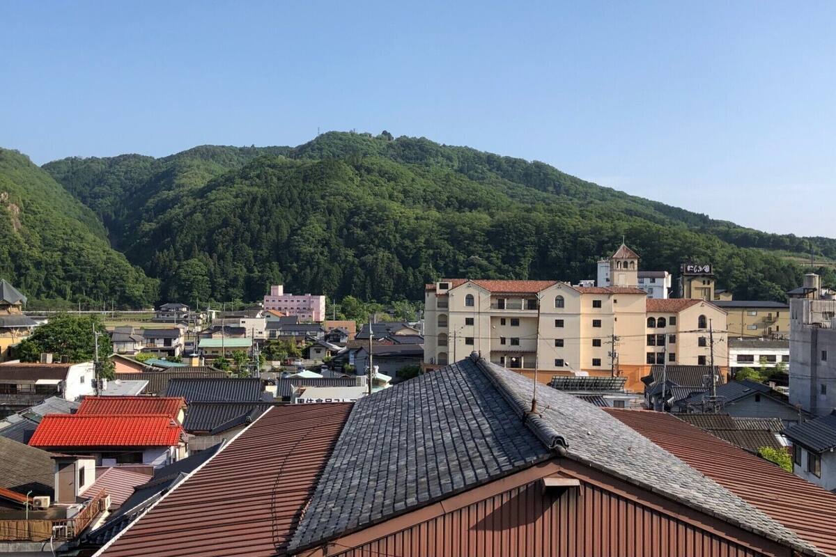Uma cidade com edifícios tradicionais e uma colina ao fundo.