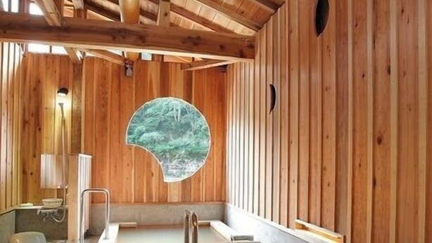 A wooden spa with a hot tub, a window with a forest view, and a sauna. - Ryokan Tamanashi Onsen Ebisuya (Kaneyama)