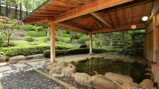 A traditional Japanese garden with a wooden pavilion, a koi pond, and meticulously maintained greenery. - Yakushido Spa (Oshu)