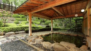 A traditional Japanese garden with a wooden pavilion, a koi pond, and meticulously maintained greenery. - Yakushido Spa (Oshu)
