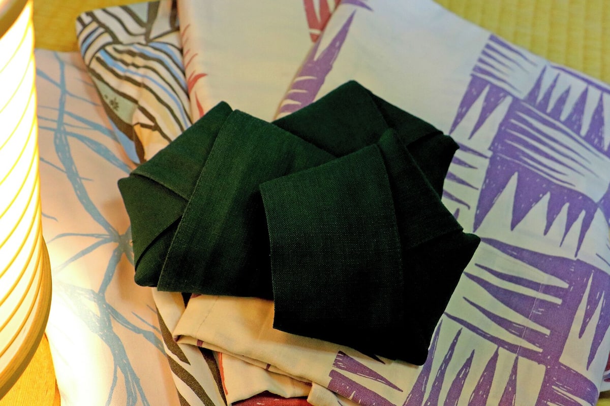 A stack of folded clothes on a patterned fabric.