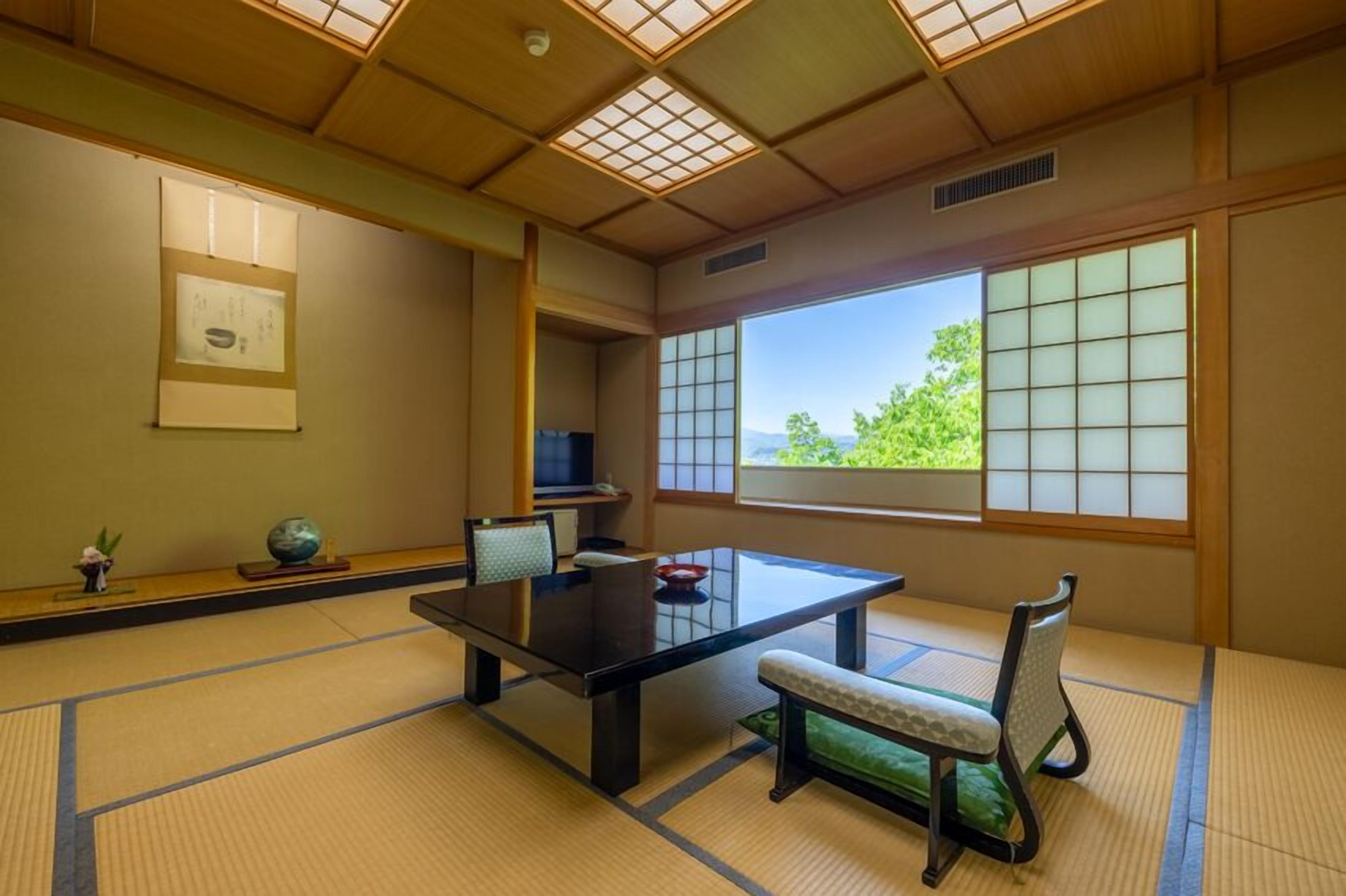 A traditional Japanese room with tatami flooring, a low table, and sliding doors.