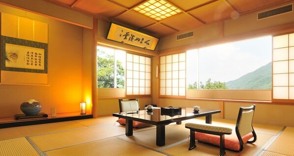 Um quarto japonês tradicional, com tatames, uma mesa baixa e portas deslizantes.