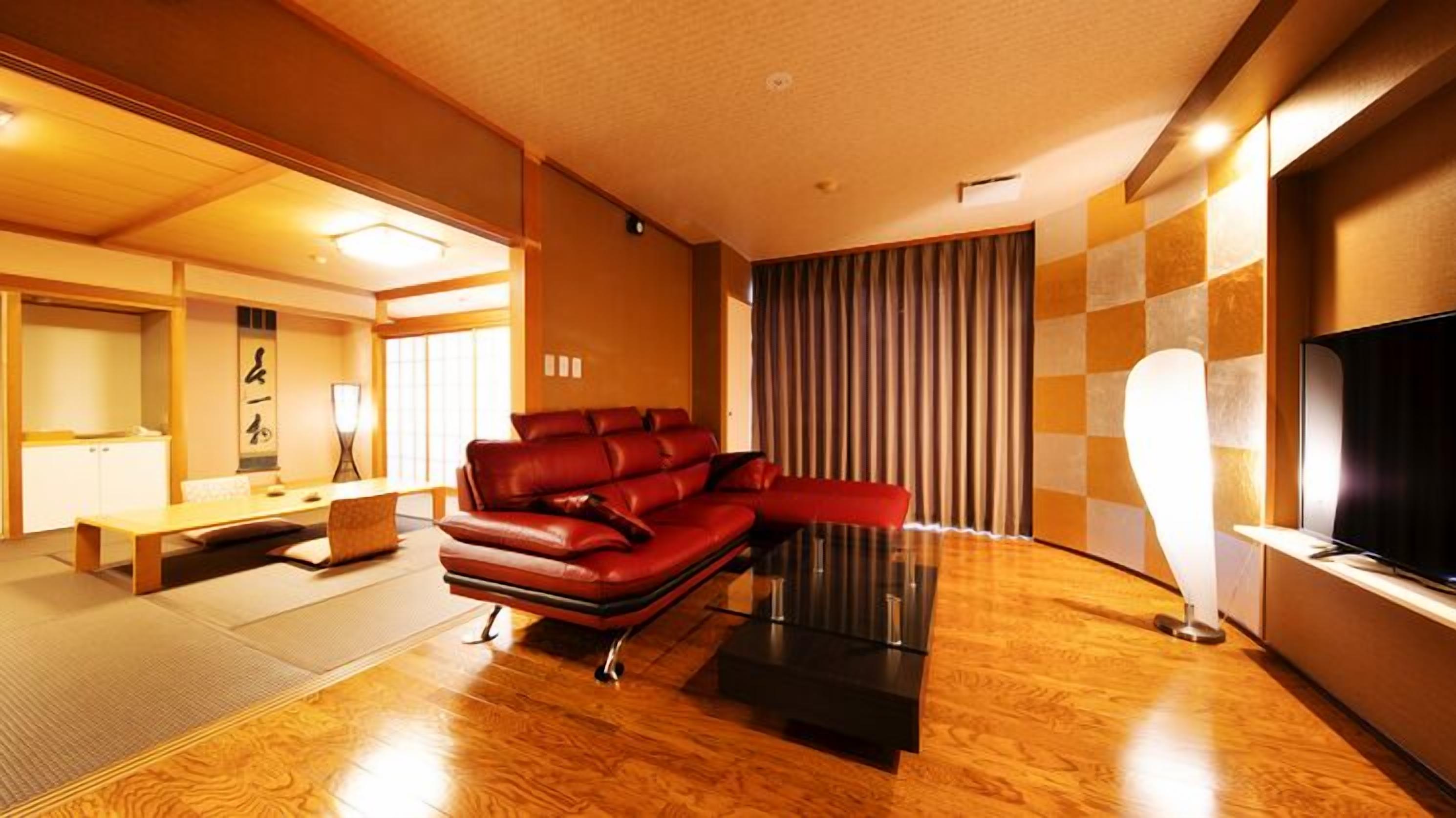 A living room with a red sofa, a coffee table, a TV, and a sliding door.