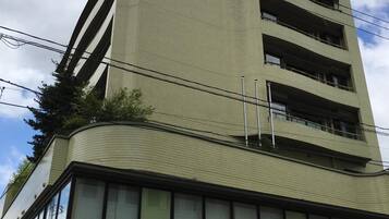 A multi-story building with a flat roof and a sign indicating it is a hotel.
