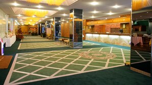 A hotel lobby with a green carpet, a reception desk, and a staircase. - Muroran Prince Hotel (Muroran)