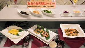 A buffet table with various dishes, including sushi and vegetables, and a sign in a foreign language. - Muroran Prince Hotel (Muroran)