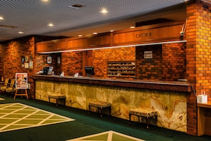 A brick-walled bar area with a cash register, bar stools, and a menu board. - Muroran Prince Hotel (Muroran)