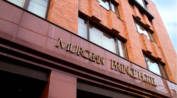 El exterior del MURORAN PRINCEHOTEL, con fachada de ladrillo rojo y amplias ventanas.