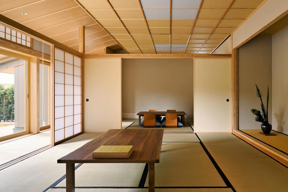 A traditional Japanese room with tatami flooring, a low wooden table, and sliding doors.