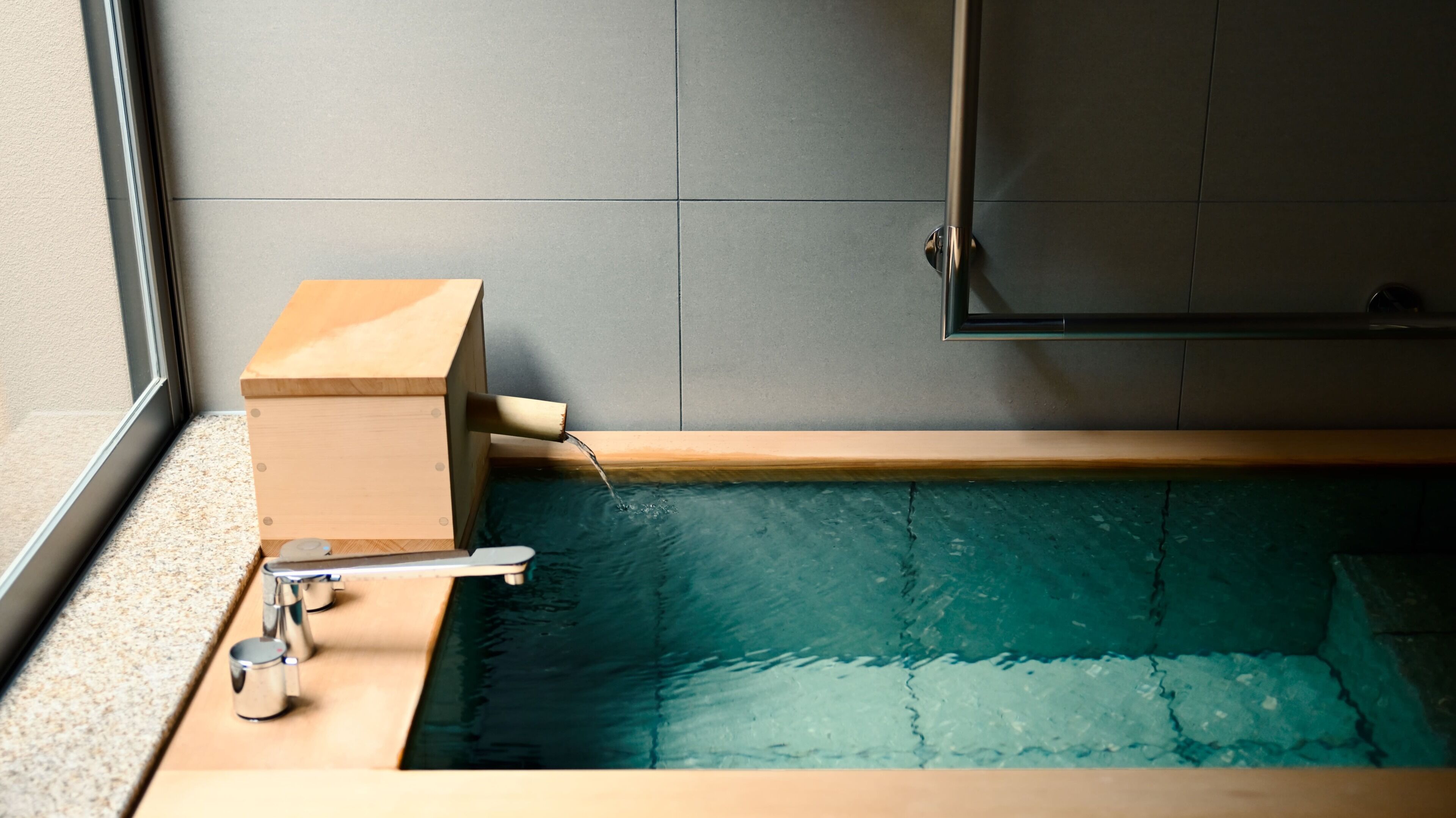 A bathtub with a wooden frame, a faucet, and a showerhead.
