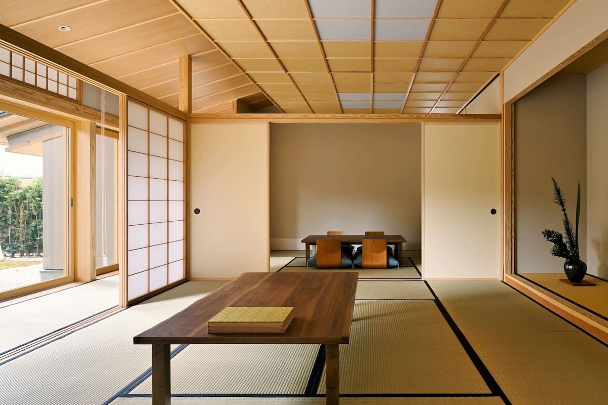 A traditional Japanese room with tatami flooring, a low wooden table, and sliding doors.