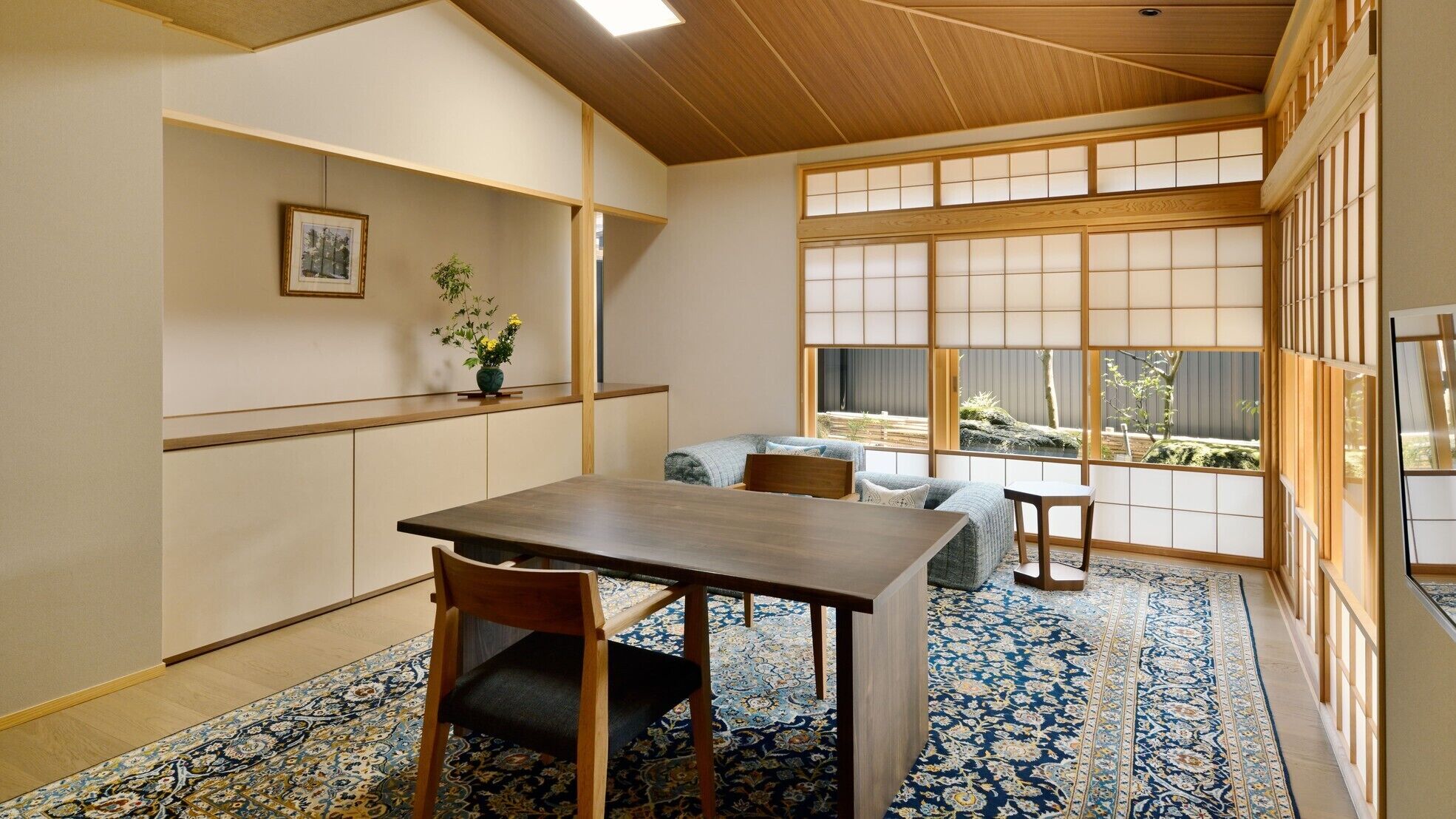 A traditional Japanese room with tatami flooring, a low table, and a sofa.