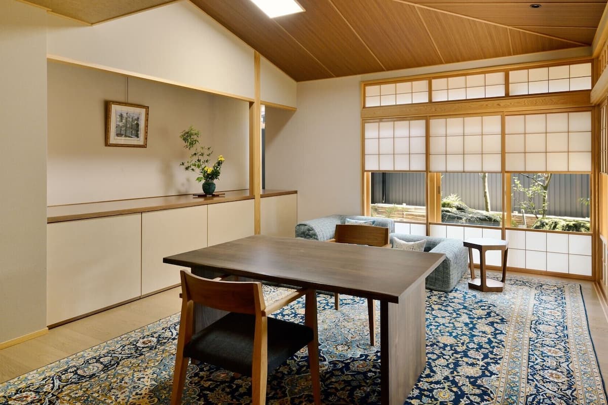 A traditional Japanese room with tatami flooring, a low table, and a sofa.