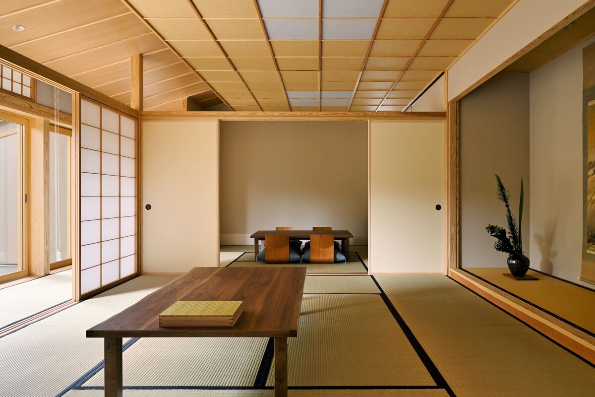 A traditional Japanese room with tatami flooring, a low wooden table, and sliding doors.