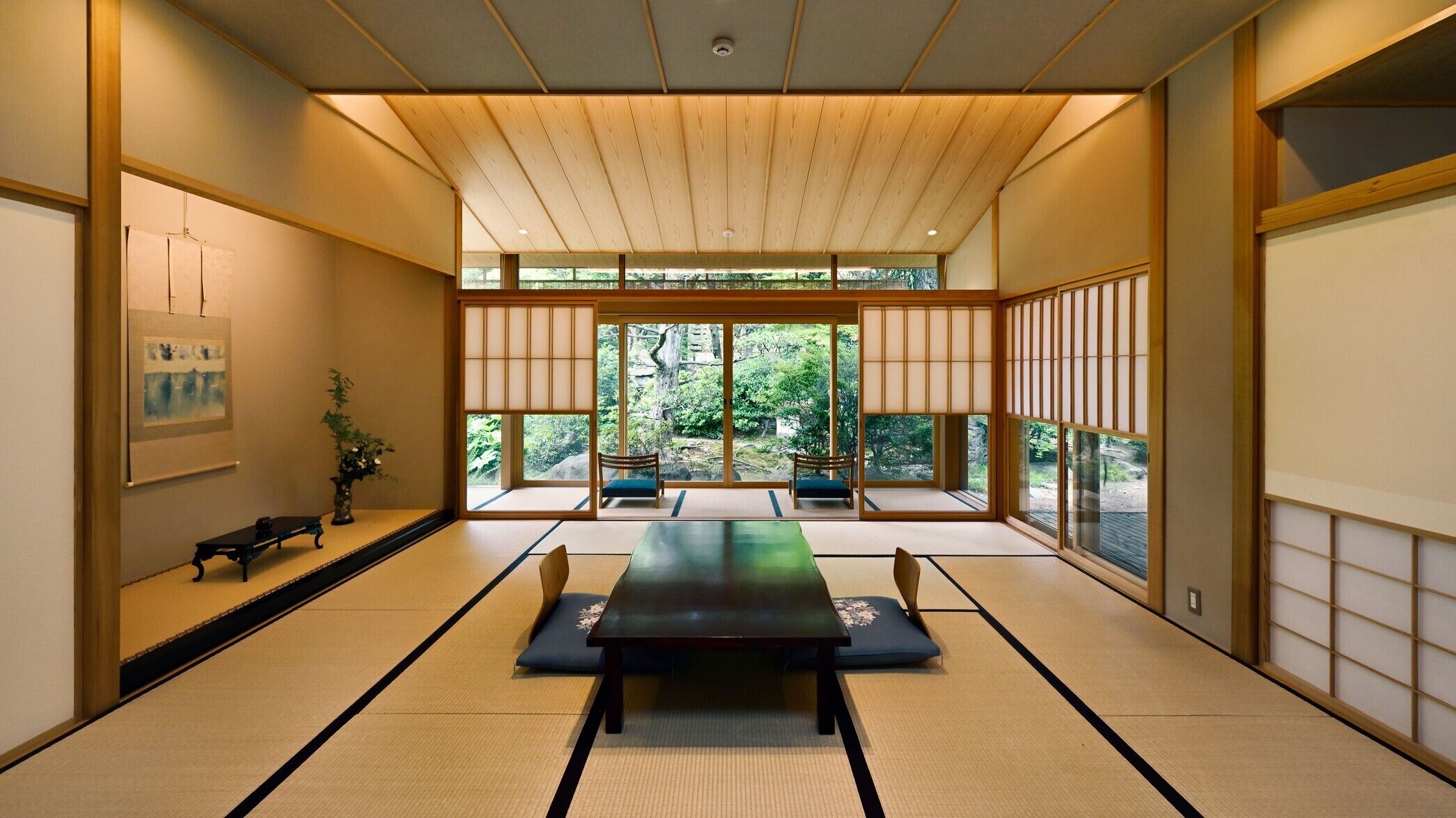 A traditional Japanese room with tatami flooring, a low table, and sliding doors.