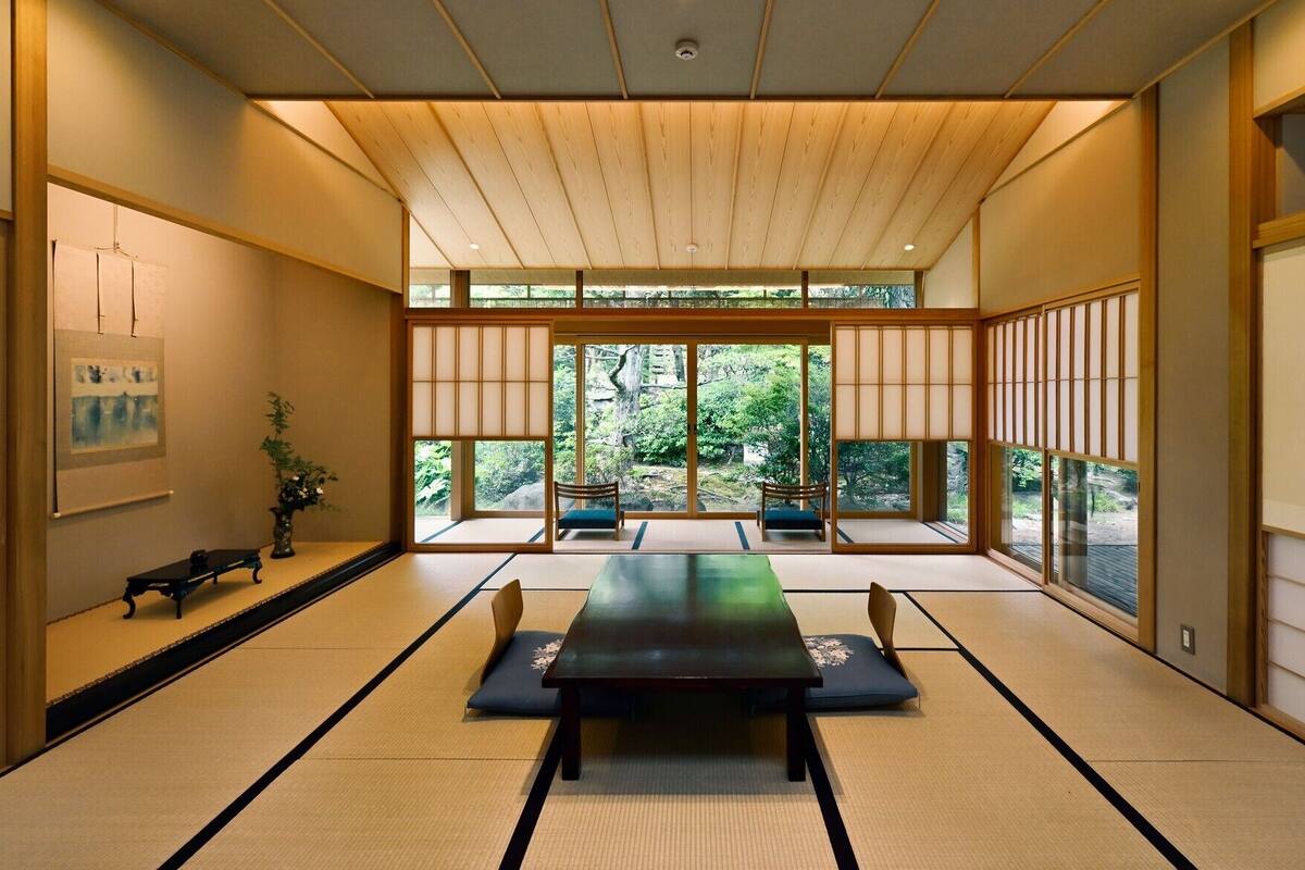 A traditional Japanese room with tatami flooring, a low table, and sliding doors.